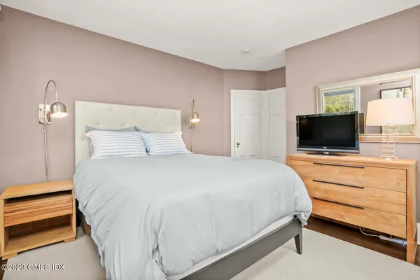 a bedroom with a bed and a flat screen tv