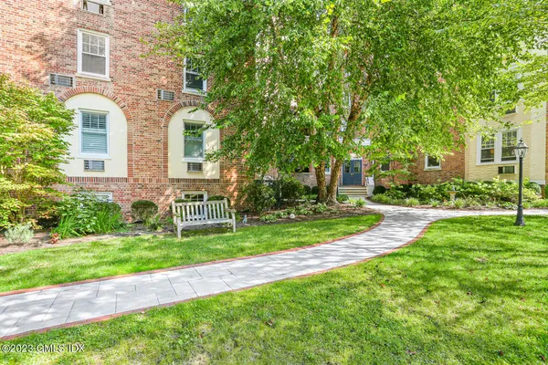 a front view of a house with a yard and potted plants