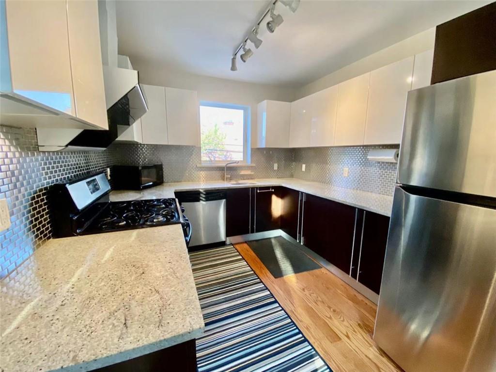 1244 Avenue X, Unit 2A Brooklyn, NY 11235 - Photo 2 of 14 a kitchen with stainless steel appliances granite countertop a sink a stove and a refrigerator