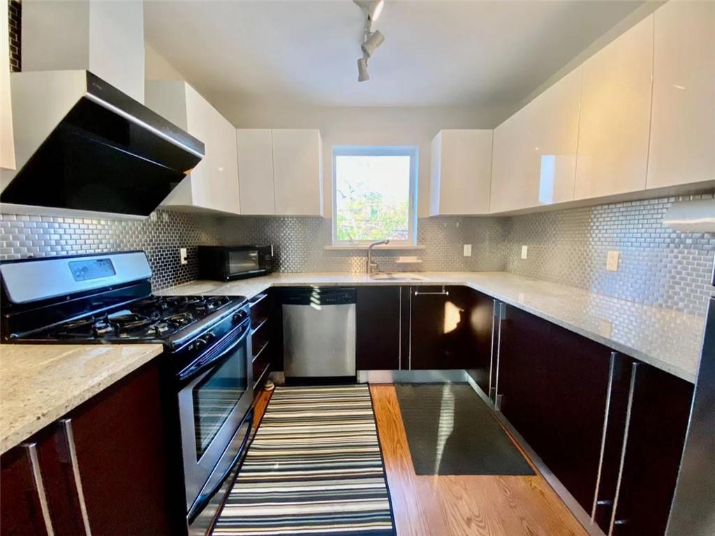 1244 Avenue X, Unit 2A Brooklyn, NY 11235 - Photo 7 of 14 a kitchen with a sink a stove and a microwave