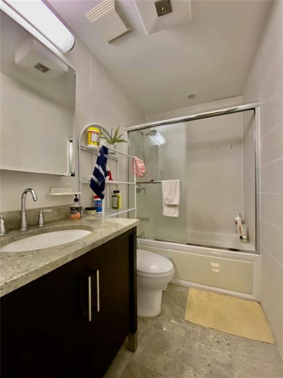 1244 Avenue X, Unit 2A Brooklyn, NY 11235 - Photo 9 of 14 a bathroom with a granite countertop sink toilet and shower
