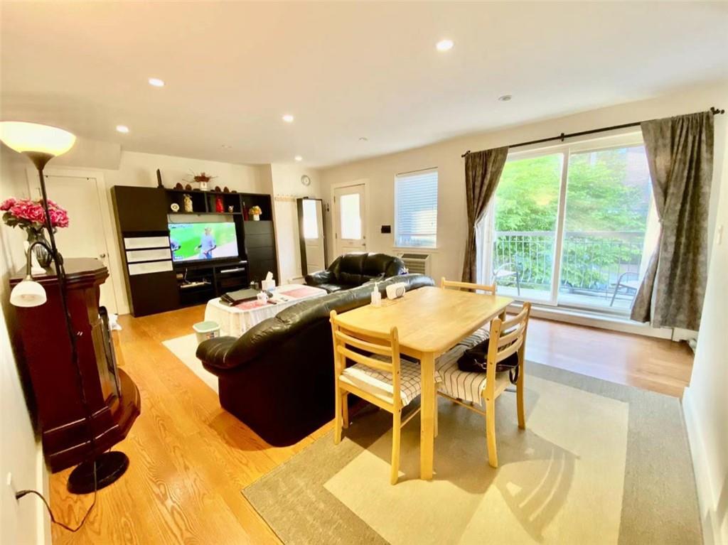 1244 Avenue X, Unit 2A Brooklyn, NY 11235 - Photo 10 of 14 a living room with furniture a flat screen tv and a large window