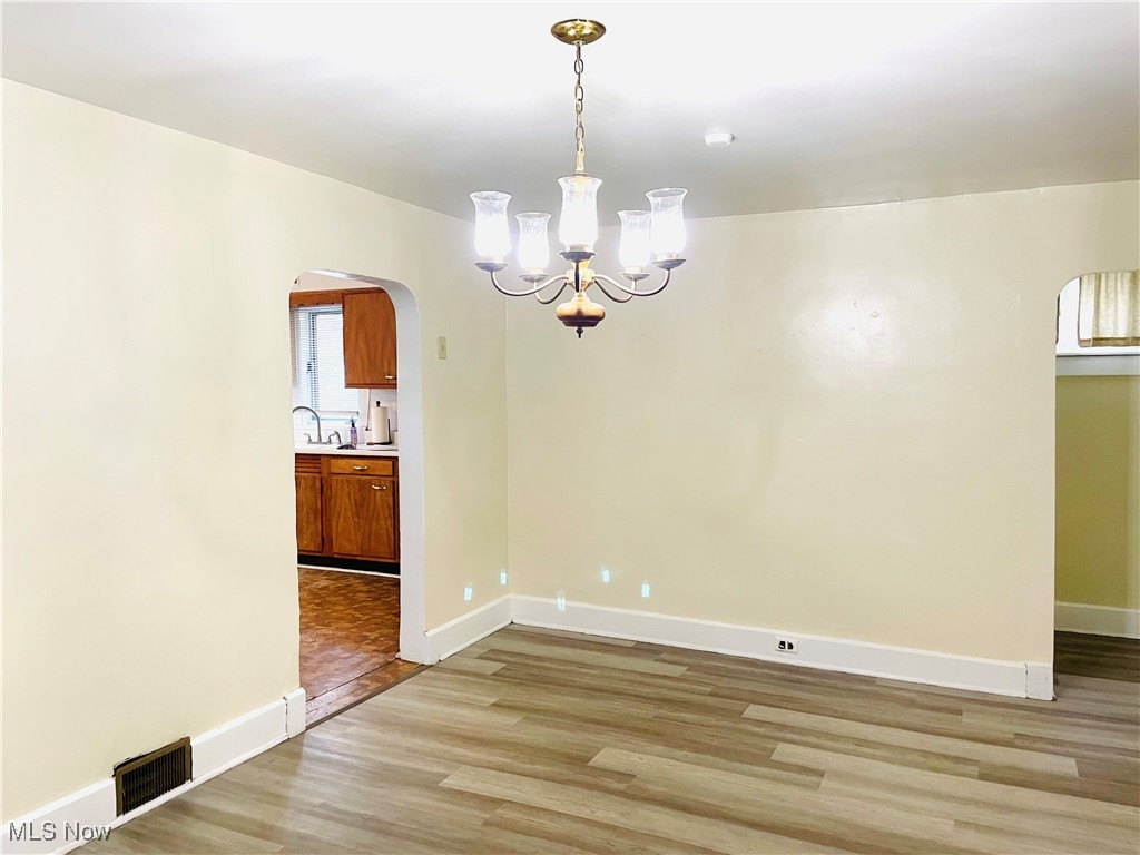 495 5th Street Struthers, OH 44471 - Photo 5 of 26 Unfurnished dining area with sink, a chandelier, and light hardwood / wood-style flooring