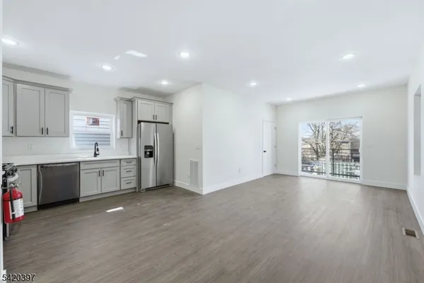 a large kitchen with wooden floors and white stainless steel appliances