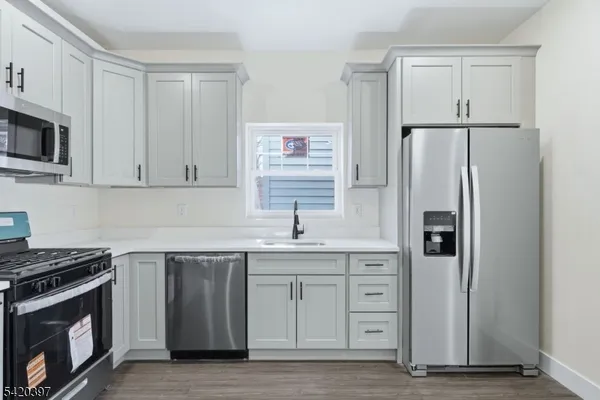 a kitchen with stainless steel appliances granite countertop a refrigerator stove and sink