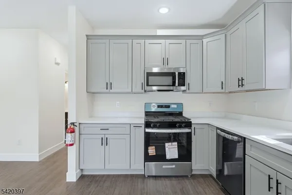 a kitchen with white cabinets and stainless steel appliances