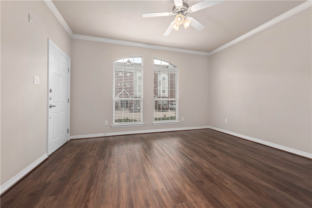1198 Jones-Butler Road, Unit 2901 College Station, TX 77840 - Photo 6 of 22 Empty room featuring ceiling fan, dark hardwood / wood-style flooring, and crown molding