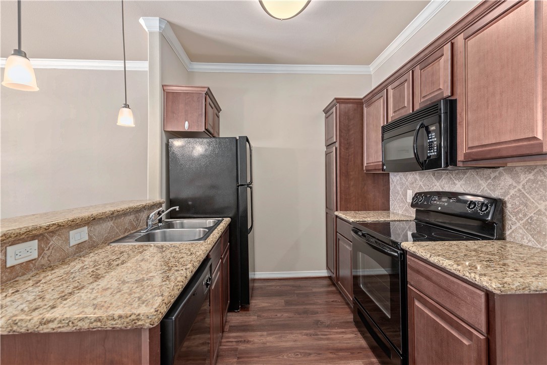 1198 Jones-Butler Road, Unit 2901 College Station, TX 77840 - Photo 9 of 22 Kitchen featuring sink, decorative light fixtures, dark wood-type flooring, and black appliances