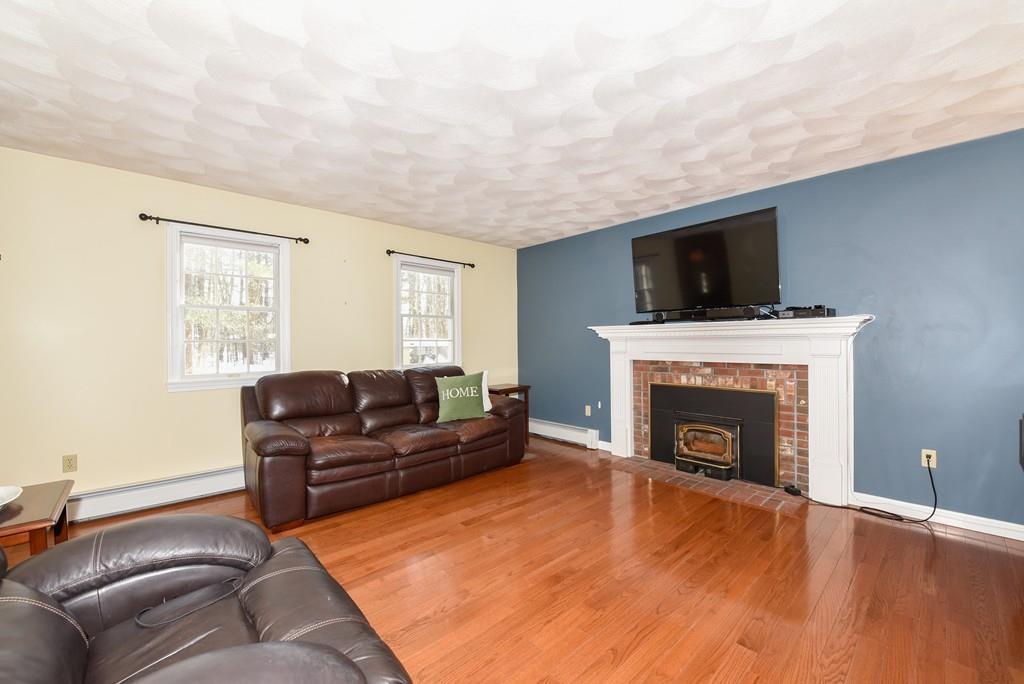 624 Boston Road Groton, MA 01450 - Photo 11 of 25 a living room with furniture a flat screen tv and a fireplace