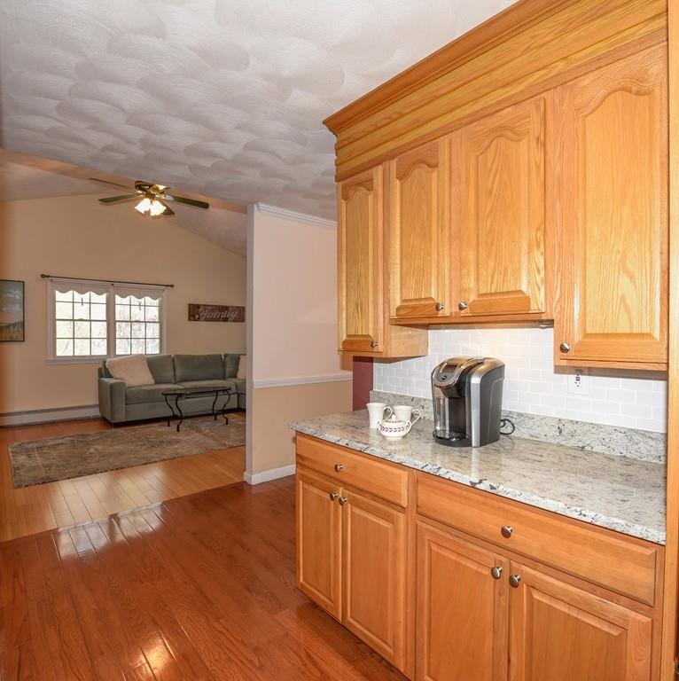 624 Boston Road Groton, MA 01450 - Photo 7 of 25 a kitchen with granite countertop a sink dishwasher a stove and white cabinets with wooden floor