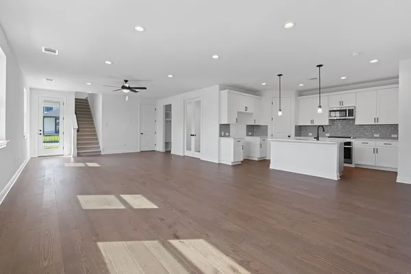 a view of a kitchen with cabinets and wooden floor