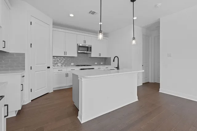 a kitchen with kitchen island a sink stainless steel appliances and cabinets