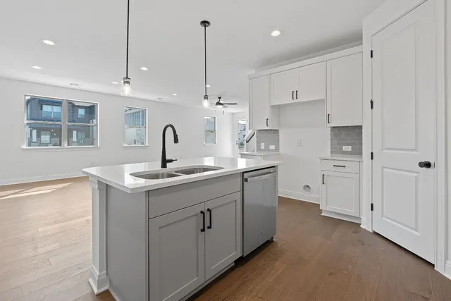 a kitchen with white cabinets appliances and a center island