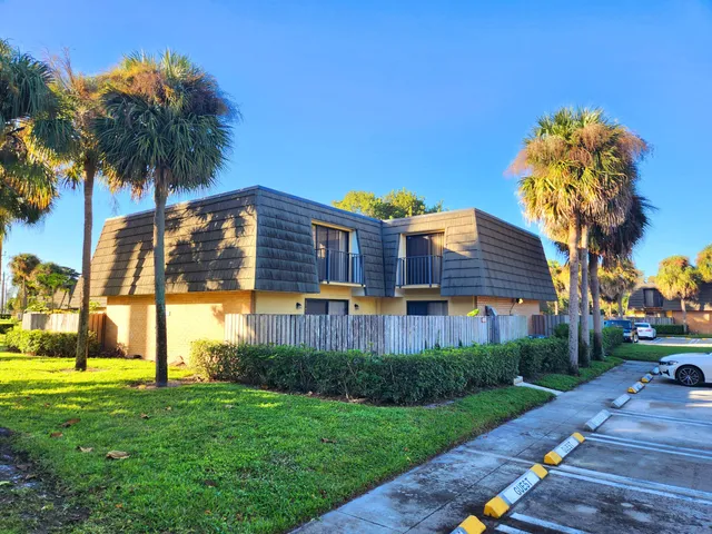 a front view of a house with garden and swimming pool