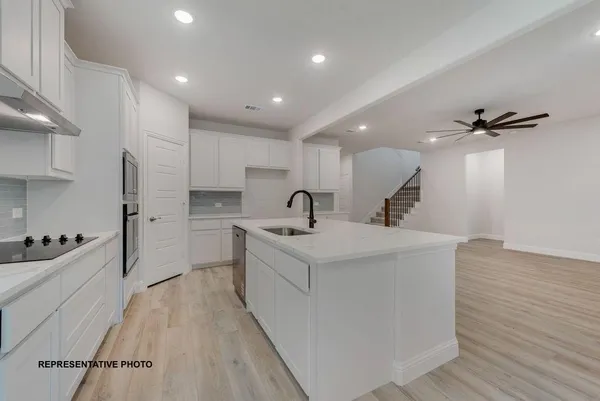 a view of kitchen with sink refrigerator and wooden floor