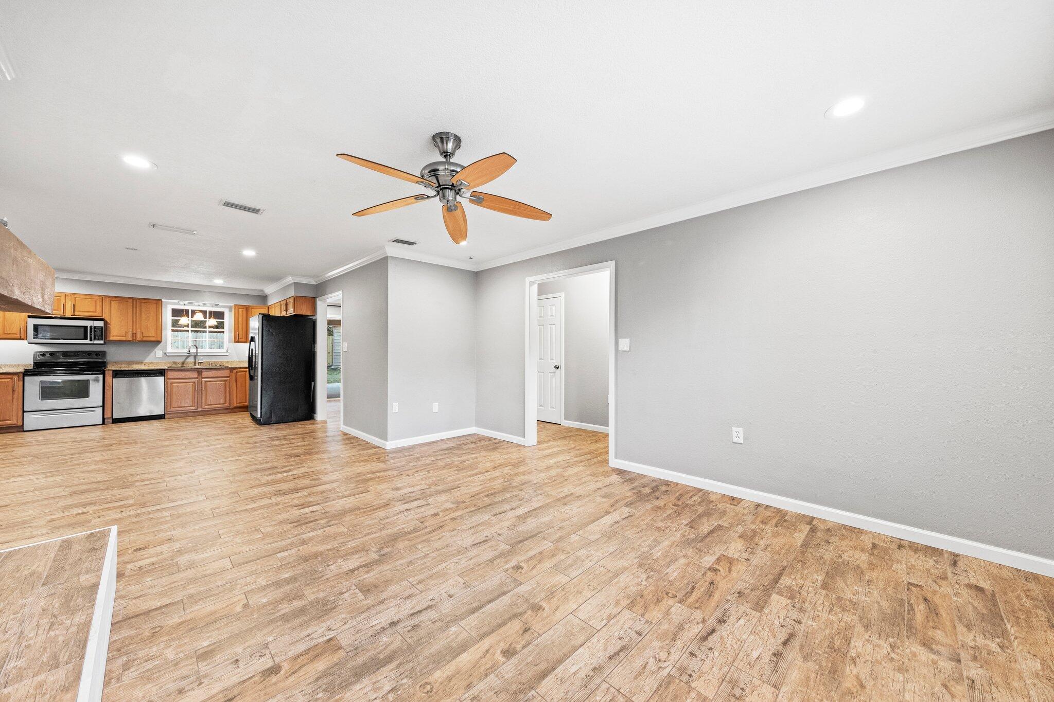 226 Terri Cove Niceville, FL 32578 - Photo 11 of 42 a view of a big room with wooden floor and a ceiling fan