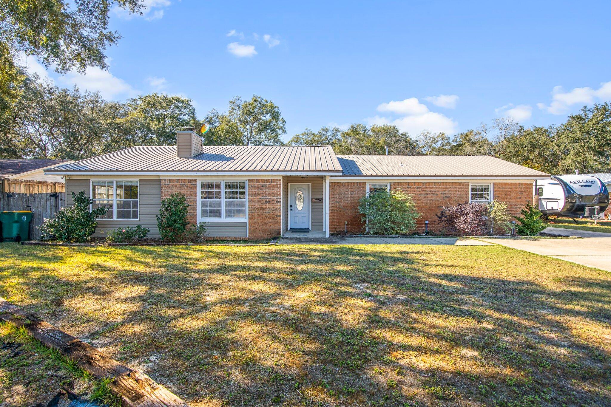 226 Terri Cove Niceville, FL 32578 - Photo 2 of 42 a front view of a house with a garden and patio