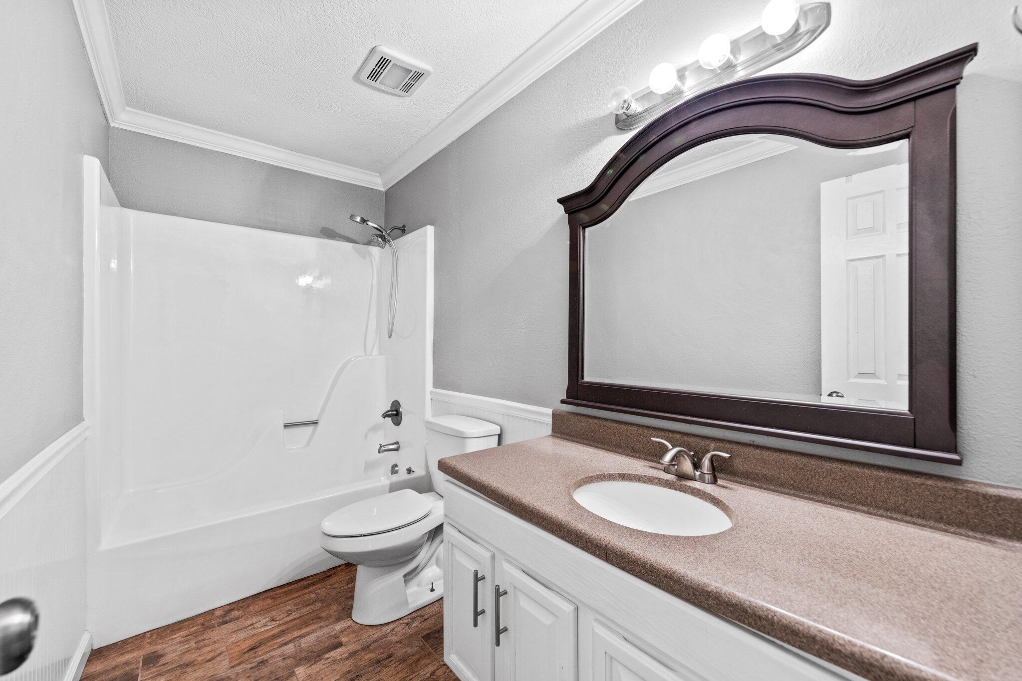 226 Terri Cove Niceville, FL 32578 - Photo 31 of 42 a bathroom with a granite countertop toilet a sink and a mirror