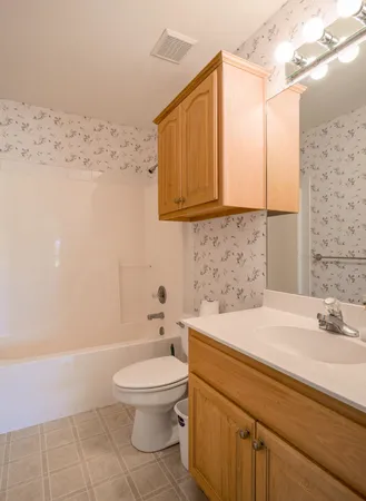 an empty room with windows and chandelier fan
