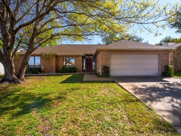 a front view of house with yard and trees around