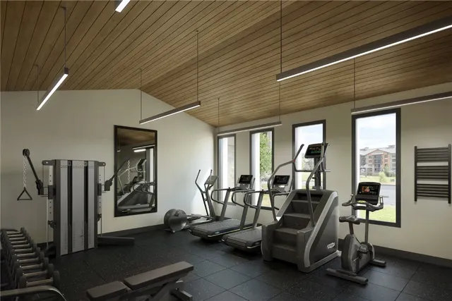 a view of water heater and a room with wooden floor