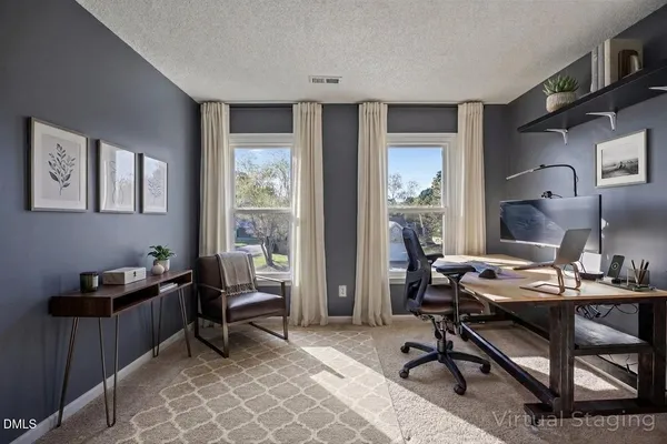a view of a workspace with furniture and a window