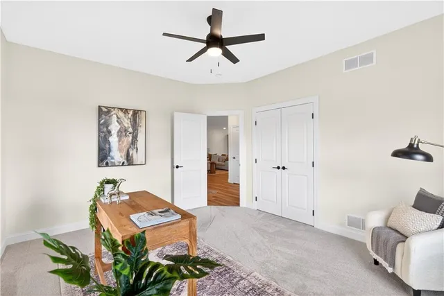 a living room with furniture a window and a ceiling fan