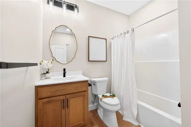 a bathroom with a toilet sink vanity tub and mirror