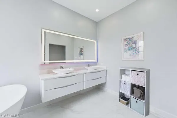 a bathroom with a double vanity sink mirror and bathtub