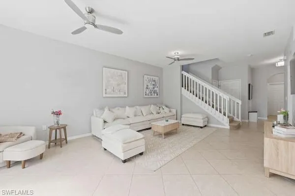a living room with furniture and a ceiling fan