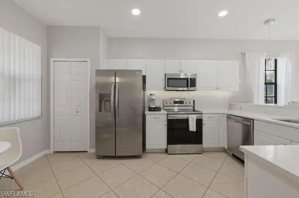 a kitchen with stainless steel appliances granite countertop a refrigerator sink and stove