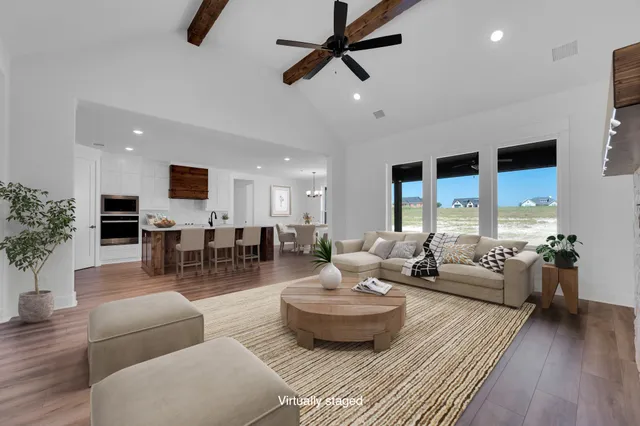 a living room with furniture and a view of kitchen