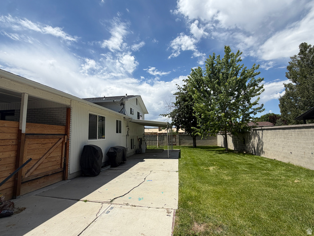 375 East 10560 South Sandy, UT 84070 - Photo 19 of 21 Expansive backyard featuring a concrete patio, a lush green lawn, mature trees, and a block wall perimeter