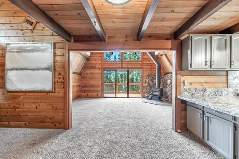 a view of an empty room with a fireplace and a large window