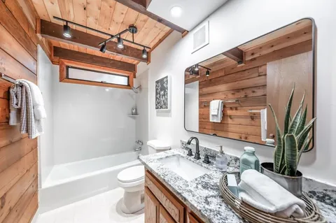 a bathroom with a granite countertop sink and a mirror