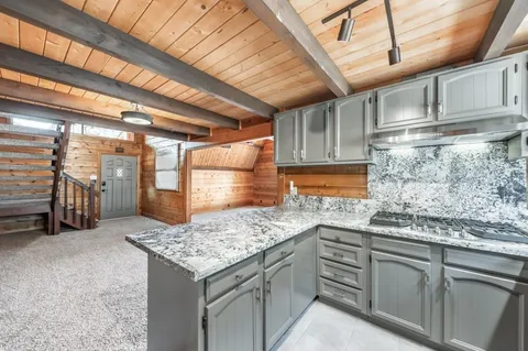 a kitchen with granite countertop stainless steel appliances and wooden cabinets