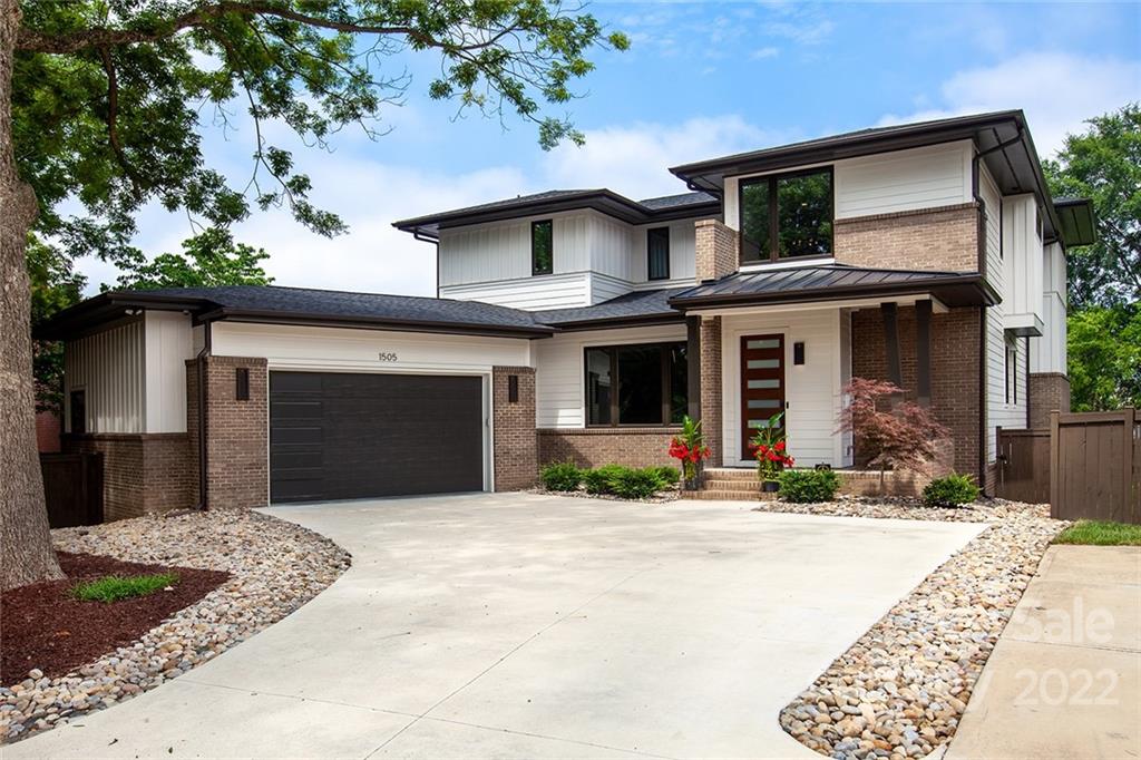 a front view of a house with a garden and plants
