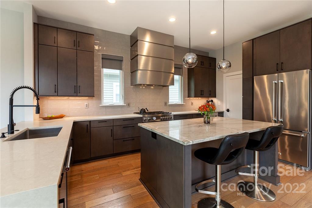 1505 Parson Street Charlotte, NC 28205 - Photo 5 of 48 a kitchen with stainless steel appliances kitchen island granite countertop a sink refrigerator and cabinets