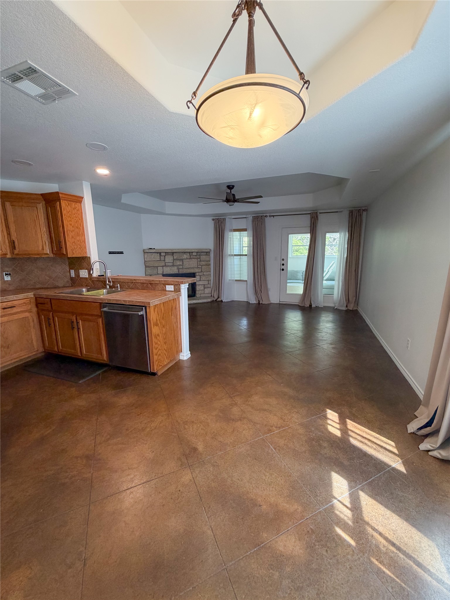 430 Summit Ridge Drive North Point Venture, TX 78645 - Photo 38 of 39 Kitchen with a raised ceiling, a peninsula, wood finish cabinetry, open floor plan, and a ceiling fan