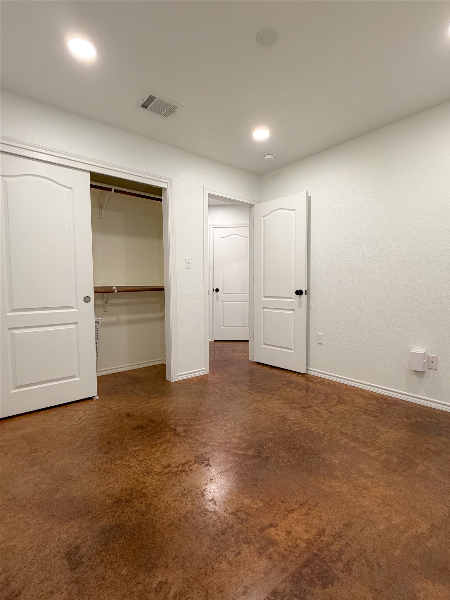 430 Summit Ridge Drive North Point Venture, TX 78645 - Photo 25 of 39 Unfurnished bedroom with concrete floors, a closet, and recessed lighting