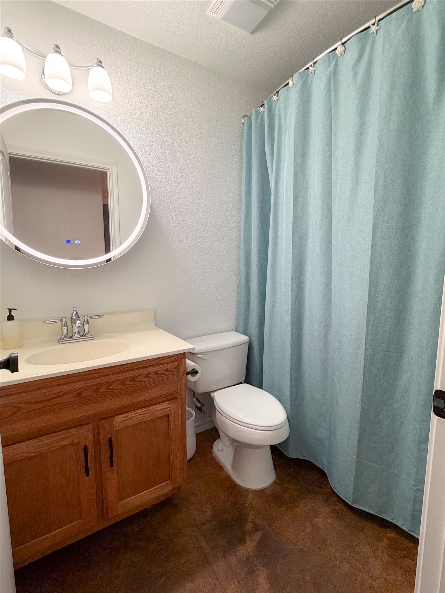 430 Summit Ridge Drive North Point Venture, TX 78645 - Photo 27 of 39 Full bathroom with vanity, a shower with shower curtain, a textured wall, and concrete flooring