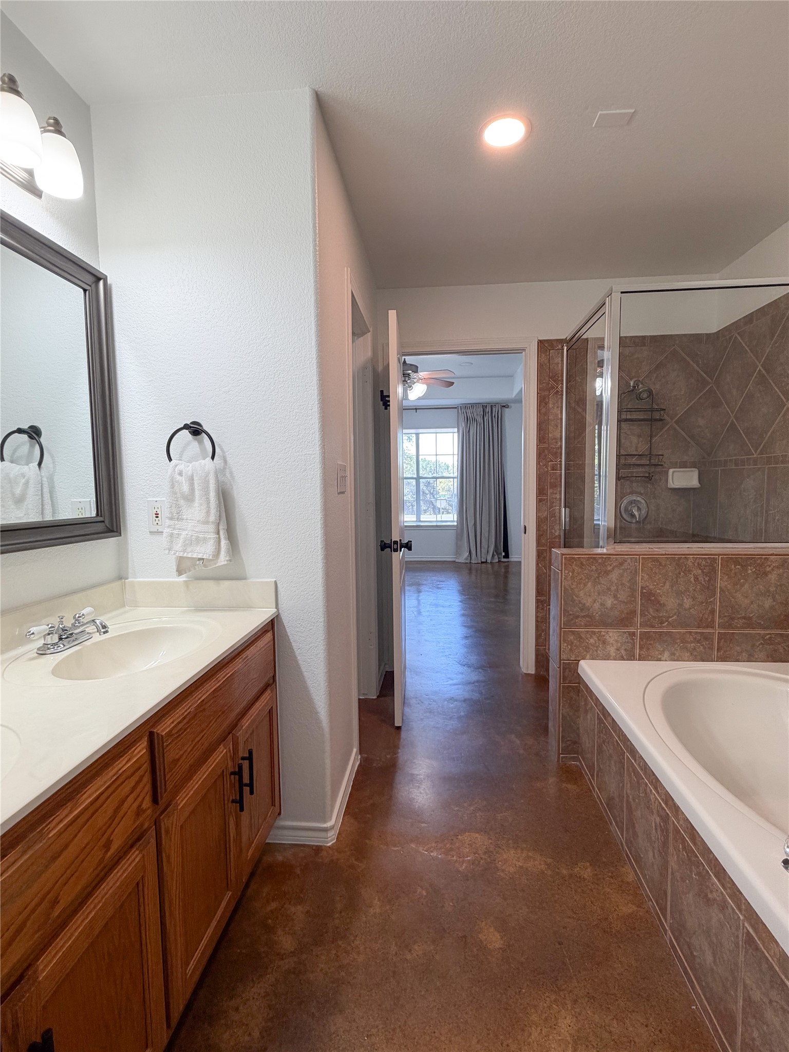 430 Summit Ridge Drive North Point Venture, TX 78645 - Photo 9 of 39 Bathroom featuring double vanity, a stall shower, finished concrete flooring, a bath, and a ceiling fan