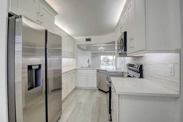 a kitchen with sink cabinets and stainless steel appliances