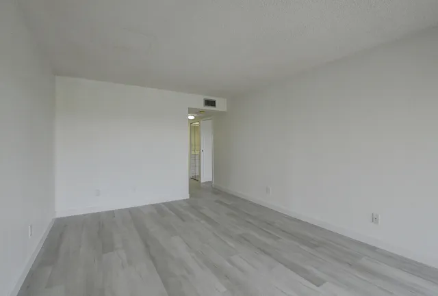 a view of an empty room with wooden floor