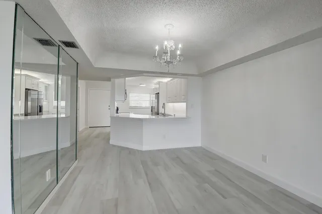 a view of a kitchen with a sink dishwasher a refrigerator and wooden floor