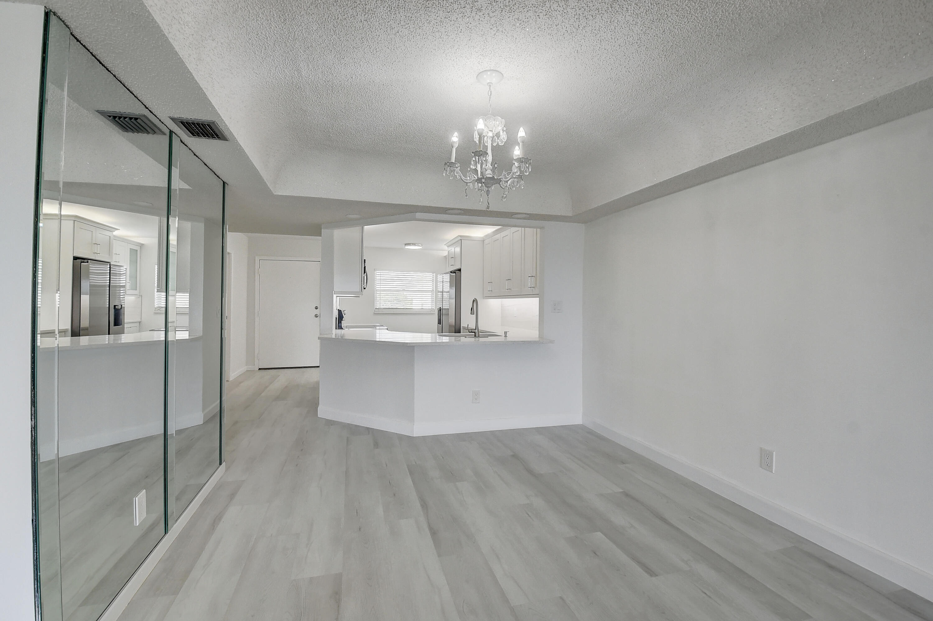 23305 Barwood Lane North, Unit 406 Boca Raton, FL 33428 - Photo 3 of 41 a view of a kitchen with a sink dishwasher a refrigerator and wooden floor