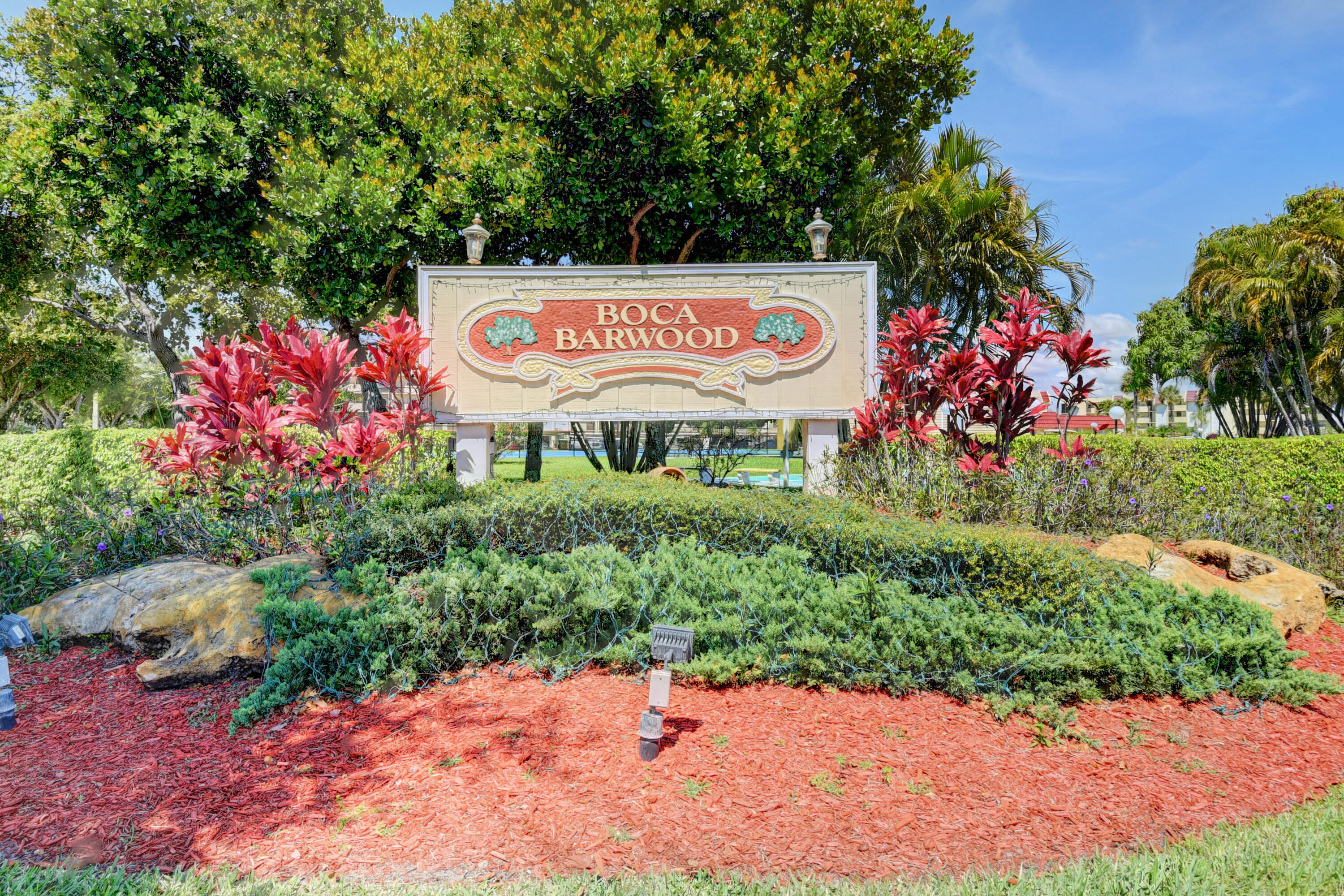 23305 Barwood Lane North, Unit 406 Boca Raton, FL 33428 - Photo 36 of 41 a sign that is in front of flowers