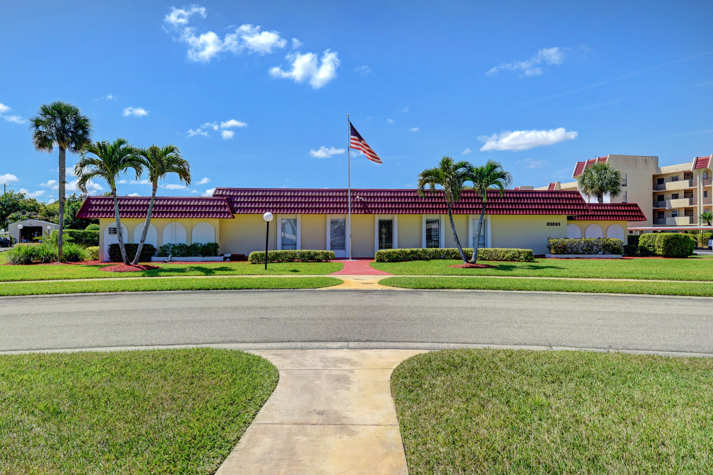 23305 Barwood Lane North, Unit 406 Boca Raton, FL 33428 - Photo 37 of 41 a front view of a house with a big yard and potted plants