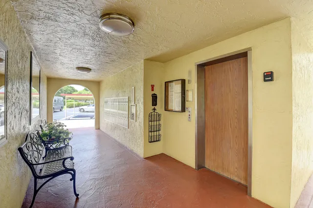 a view of a hallway with furniture and a window