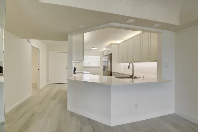 a view of kitchen with center island wooden floor and living room